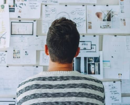 designer looking at idea board